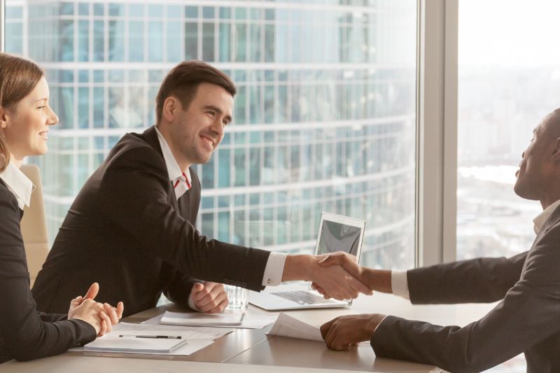 Business People handshaking at a conference table